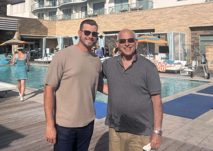 Two attendees on the Paséa pool deck at a Trial Lawyers University event
